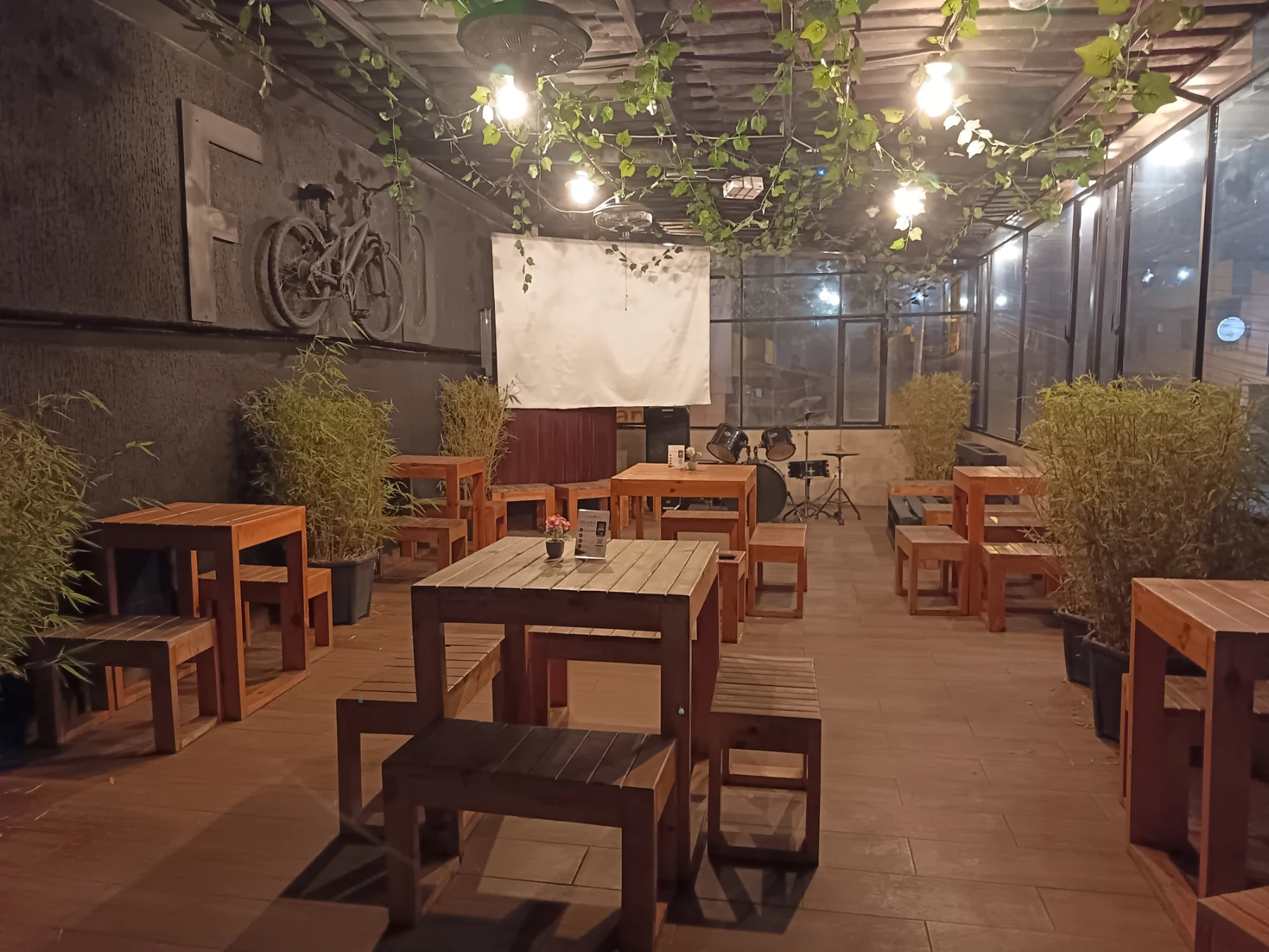 Terraza de Carbonal con mesas de madera y vegetación